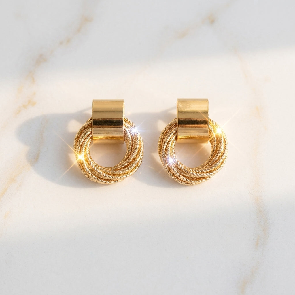 Gold twisted circle stud earrings with woven geometric design