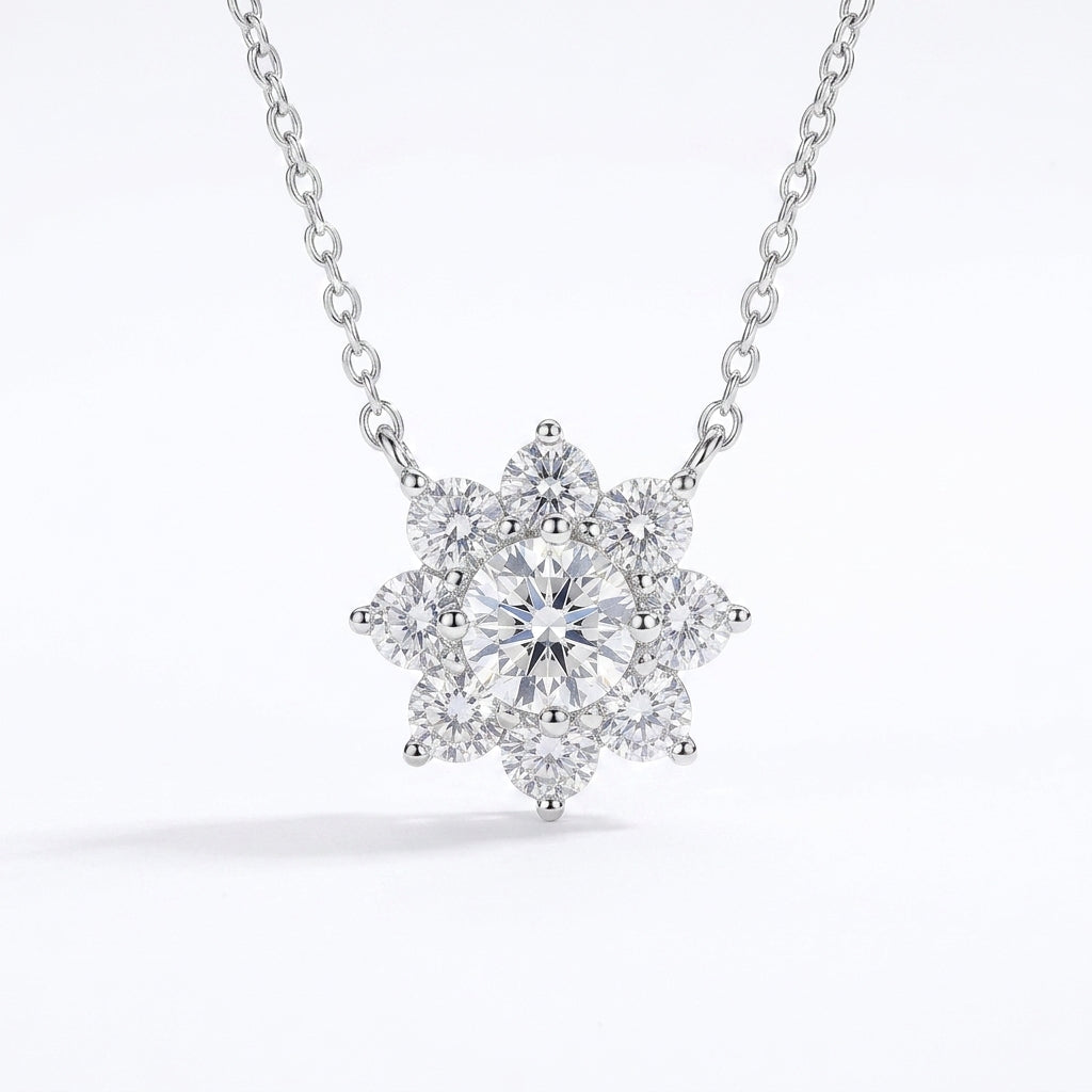 A silver-tone necklace with a snowflake-shaped cluster pendant featuring a central round diamond surrounded by smaller diamonds, shown on a clean white background.
