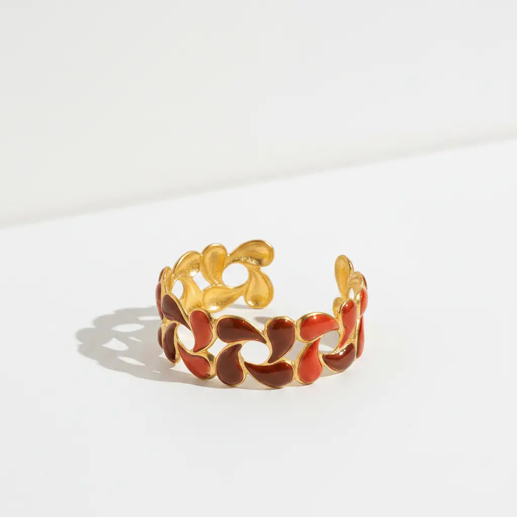 a red and burgundy color enamel adjustable ring on a white background